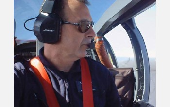 man with headset in cockpit of plane