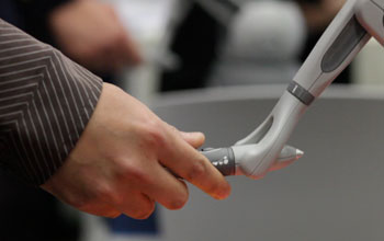 human hand holding a robotic hand
