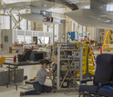 woman working in a facility to  mount air-sampling instruments on airplane