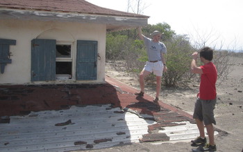 E. Bruce Pitman and colleague next to a house damaged by mudslides in Montserrat