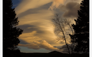 A stacked lenticular cloud is seen at sunset in the fall in Nederland, Colo.