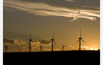 Turbines on the Cedar Creek wind farm are silhouetted against a dramatic sunset