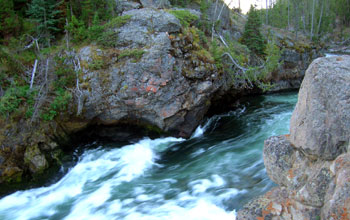 A river at the brink of Lower Falls in Yellowstone National Park's Grand Canyon.