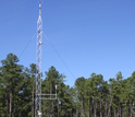 Meteorological tower next to a forest
