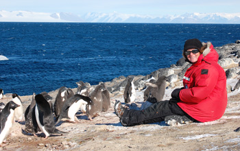 Jean Pennycook with group of Adélie penguins on the beach