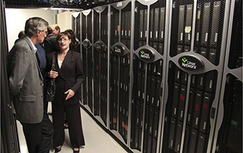 Photo of LANL Director Charles McMillan and UNM's Susan Atlas standing next to computers.