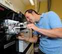 Biogeochemist Mak Saito using a machine in a lab