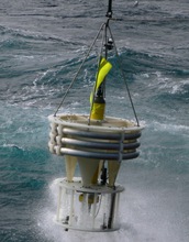 A sediment trap being lifted from the ocean by a crane