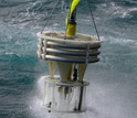 A sediment trap being lifted from the ocean by a crane