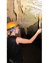 Collecting drip water from a stalactite in Cobweb Cave at Gunung Mulu National Park in Borneo