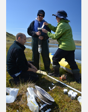 A field team slices a lake sediment core to gather diatom samples