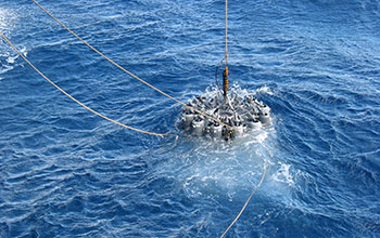 Instruments descend into ocean waters to collect water samples for a study