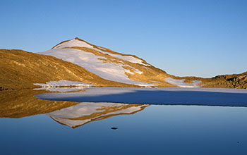 Reflection of nearby hills can be seen on the calm surface of Lake Ferris in the evening