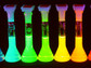 Samples showing quantum dot solutions emitting light at wavelengths across the rainbow.
