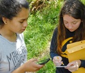 Two young women with smart phone and envelopes