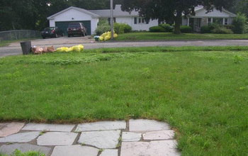 Photo of a U.S. suburban house with lawn garrage and cars parked outside