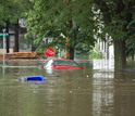 Cars floating down a flooded avenue in a Midwest town