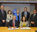 Seven representatives from NSF and DOE with documents at a meeting