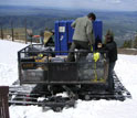 Photo of aerosol-tracking instruments being loaded onto a snow cat at the Storm Peak Lab.