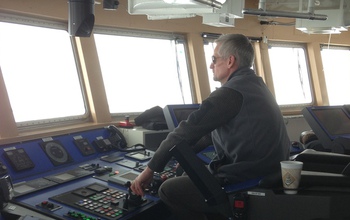 Capt. Dan Hobbs in front of operating controls of the ship