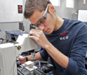 a student uses an industrial microscope