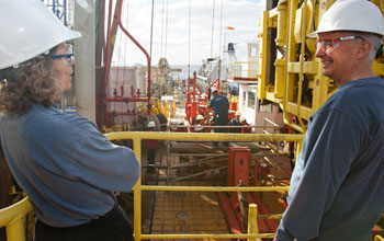 Photo of co-chief scientists Donna Blackman and Alistair Harding looking across the rig floor.