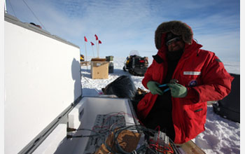 Photo of Slawek Tulaczyk installing a precision GPS sensor for monitoring a subglacial lake.