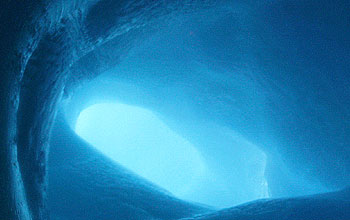 Filtered sunlight gives off blue aura inside ice tube formed around a volcanic steam vent