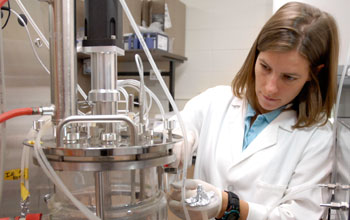 Photo of grad student Natasha Mallette working with a fermentation system for converting biomass.