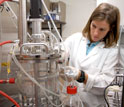 Photo of grad student Natasha Mallette working with a fermentation system for converting biomass.