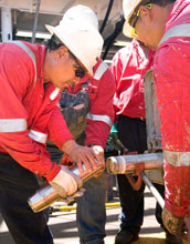 Scientists remove the core catcher from a core barrel.