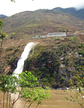 Small hydropower plant discharges water from tributary to main channel of the Nu River.