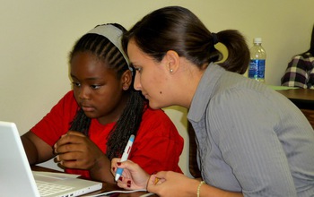 student and teacher at computer