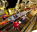 Photo of several crew members prepping an instrument that will remain under the sea-floor.