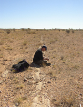 Photo of scientist Tim Lyons looking at a sample from the Georgina Basin in Queensland, Australia.