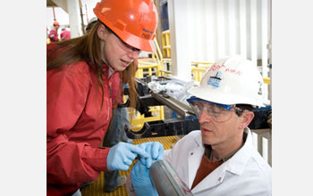 Microbiologist Maria-Cristina Ciobanu and geochemist Simon George sample a core.