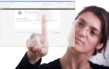 Photo of a woman touching her finger in the center of a circle on the NSF Digital Strategy web page.