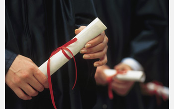 Photo of a graduate holding a diploma.