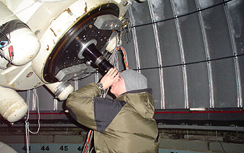 Student looking through large telescope