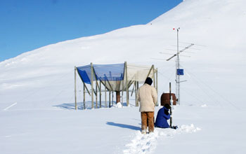 Photo of Alexander Kolodov and Mike LaDouceur examining an Arctic weathering station.