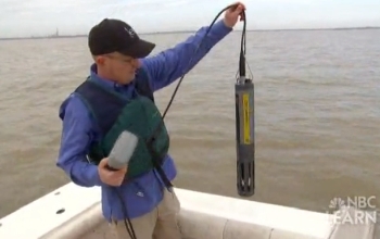 researcher holding up a sensor from the lake