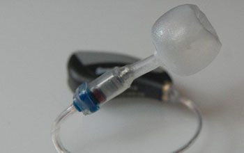 This photo shows a hybrid in-ear monitor-hearing aid technology from Asius.