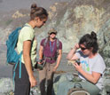 students in field analyzing rocks
