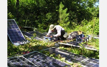 Photo of Michael Loranty connecting more wiring for the solar panels used to power the site.
