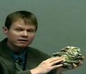 Shanan Peters holds a fossil coral and explains how sea level fluctuations cause mass extinctions.