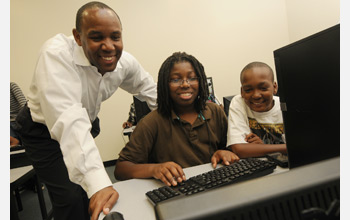 Photo of Kevin Clark and students at a computer.
