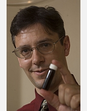 George Huber poses with a vial of green gasoline compounds.