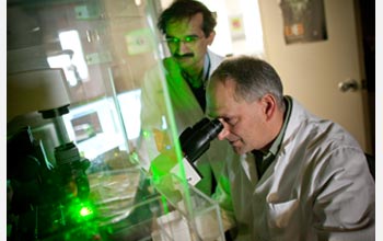 Photo of Himanshu Jain and a colleague examining materials in a laboratory.