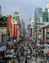 Photo showing large numbers of people and vehicles on Shanghai street and hazy, overcast sky.