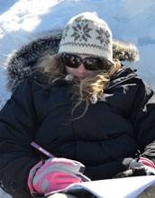 Photo of student Alexandra Schmidt taking notes during an experiment on the Greenland Ice Sheet.